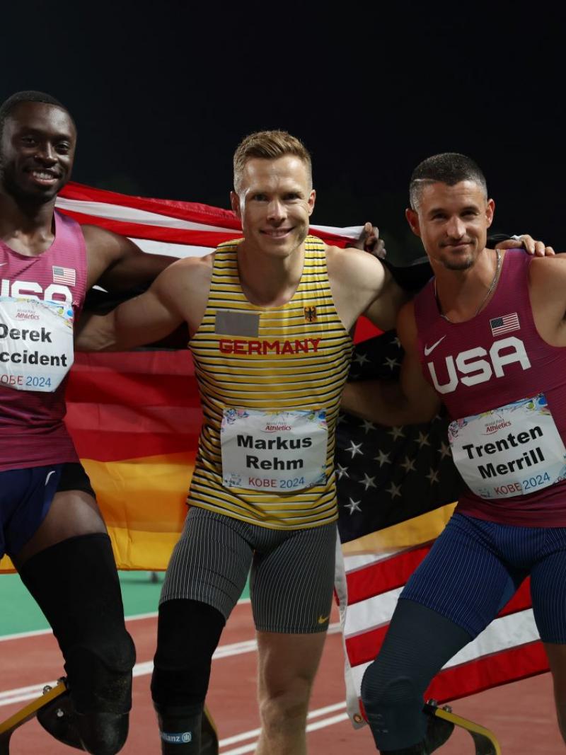 Three men with prosthetic legs posing for a picture in a competition